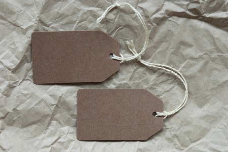 Two Brown Labels Or Tags With White Ribbon. Crumpled Paper Background With Copy Space Free Text Or...