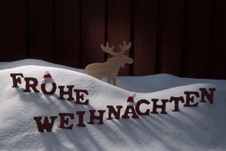 Red Letters Building German Word Frohe Weihnachten Means Merry Christmas.Decoration Card For Seasons Greetings. Snow And Snowy Scenery With Moose And Santa Hat. Wooden Background. Christmas Atmosphereの写真素材