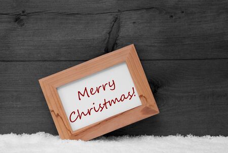 Gray Christmas Card With Brown Picture Frame On White Snow. English Text Merry Christmas. Rustic Wooden, Retro Vintage Background. Black And Whiteの写真素材