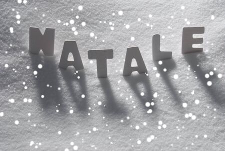 White Letters Building Italian Text Natale Means Christmas On White Snow. Snowy Landscape Or Scenery With Snowflakes. Christmas Card For Seasons Greetings Or Usable As Background.の写真素材