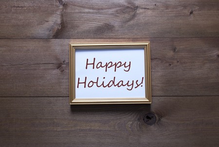 One Golden Picture Frame On Wooden Background. English Text Happy Holidays. Rutic Vintage Or Retro...