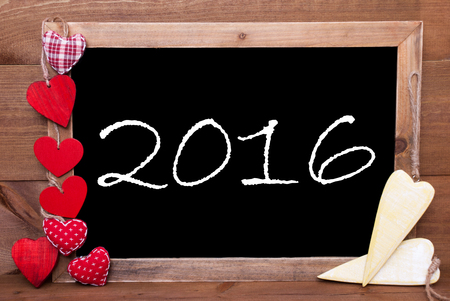 Chalkboard With Text 2016 For Happy New Year Greetings. Many Red Textile And Wooden Yellow Hearts. Wooden Background With Vintage, Rustic Or Retro Style.の写真素材