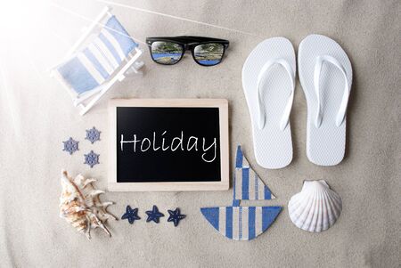 Flat Lay Of Chalkboard On Sandy Background. Sunny Summer Decoration As Holiday Greeting Card. Sand And Beach Environment. English Text Holidayの写真素材