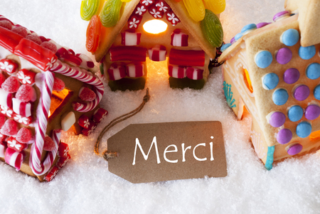 Label With French Text Merci Means Thank You. Colorful Gingerbread House On Snow. Christmas Card For Seasons Greetingsの写真素材