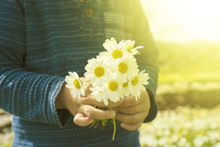 Little Child Is Holding A Bouquet Of Daisy Flowerの写真素材