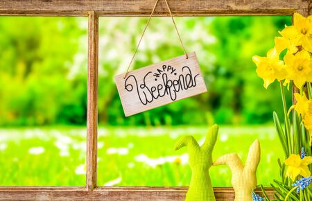 Sign With English Calligraphy Happy Weekend. Vintage Rustic Window Frame With View To Grass Meadowの写真素材