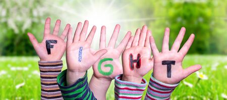 Children Hands Building Colorful English Word Fight. Sunny Green Grass Meadow As Backgroundの写真素材