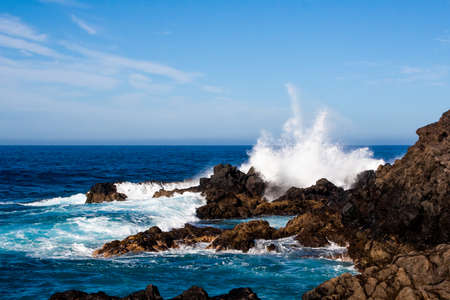 big crashing wave splashing over the rocksの写真素材