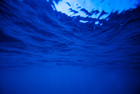 underwater background, deep blue sea with sunraysの写真素材
