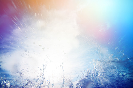 water splash against the sky and the sun. ?olorful background with sunbeamsの写真素材