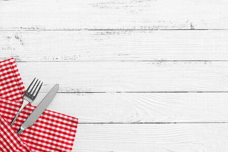 knife and fork on white old vintage wooden table with red checked tablecloth and copyspace. still life backgoundの写真素材