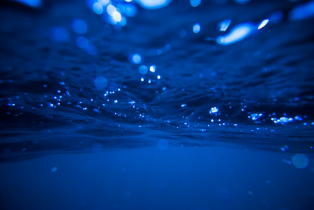 underwater background, deep blue sea with sunraysの写真素材