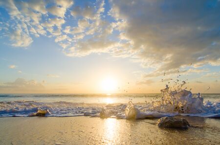 sea splash at sunset on the beachの写真素材