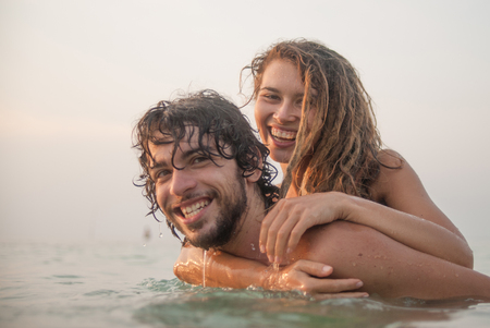 young couple having fun in the seaの写真素材