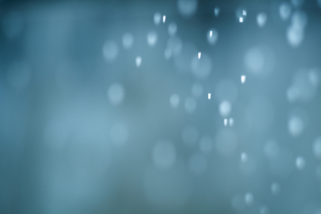 falling snow abstract blue bokeh backgroundの写真素材