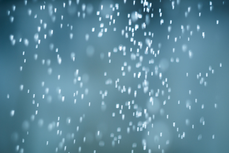 falling snow abstract blue bokeh backgroundの写真素材