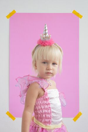 girl in a unicorn costume on a pink backgroundの写真素材