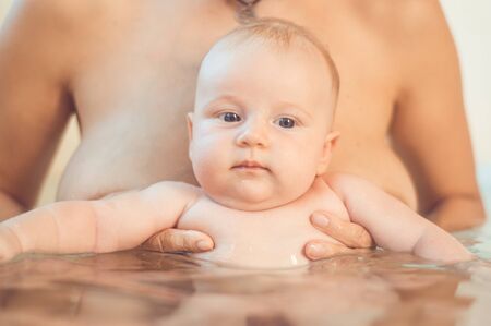 baby bathing with mother in the bathroomの写真素材