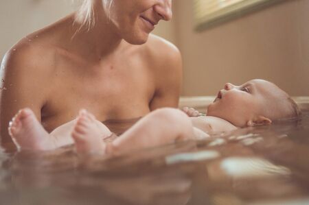 baby bathing with mother in the bathroomの写真素材
