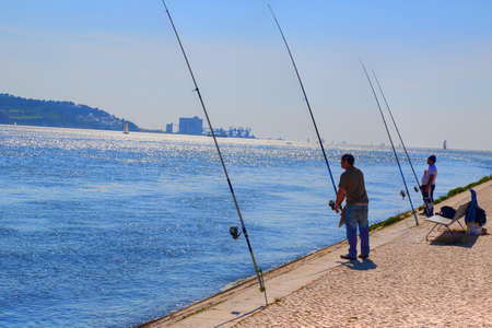 LISBON, PORTUGAL-OCTOBER 17, 2017: People fishing and enjoying the weekend near Landのeditorial素材