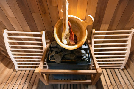 Steam and hot stone compact sauna interior with heating stone electrical device and hot water bucket