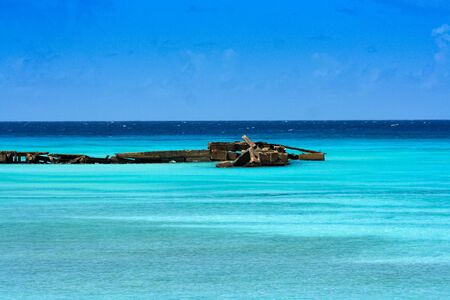 Old pier on bright blue waterの写真素材