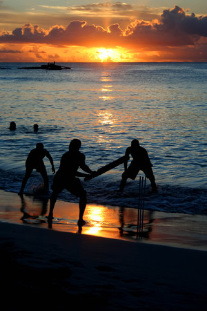 Cricket game at the beach with a beautiful sunsetの写真素材