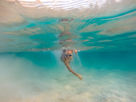 Boy swimming in a clear caribbean seaの写真素材