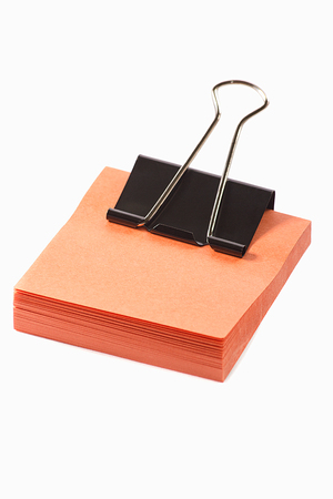 orange post note with black clip isolated on white backgroundの写真素材