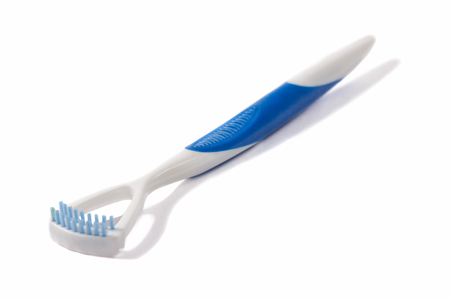 Oral Device in white color with a tongue scrapers (tongue cleaner) and blue brush to eliminate bacteria, isolated on whiteの写真素材