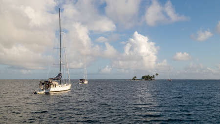 San Blas Archipelago, Panama - November 22nd, 2018: Sailing boats on the sea with and palm tree islands on the horizonのeditorial素材