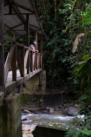 Man over a wooden bridge at Podocarpus National Park, Ecuadorの写真素材