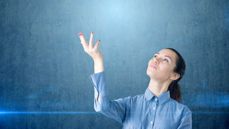Portrait of young brunette business woman looking to her hand and thinking