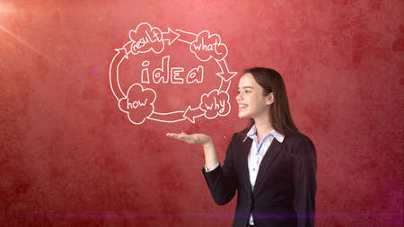 Young woman holding painted business cycle on the open hand palm, over isolated studio background. Business concept.の写真素材