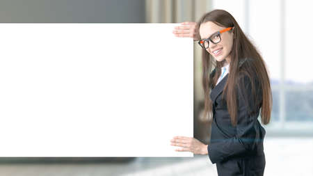 Young beautiful business woman and creative designer standing over blured interior background