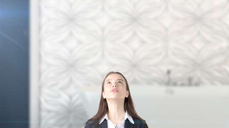 Young beautiful business woman and creative designer standing over blured interior backgroundの写真素材