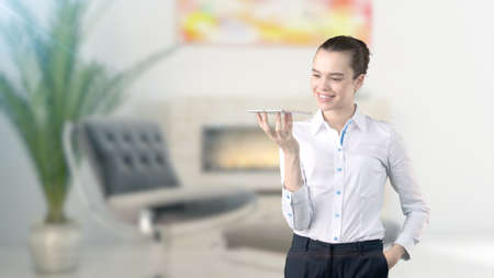 Young beautiful business woman and creative designer standing over blured interior backgroundの写真素材
