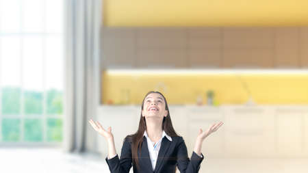 Young beautiful business woman and creative designer standing over blured interior background