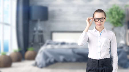 Young beautiful business woman and creative designer standing over blured interior backgroundの写真素材