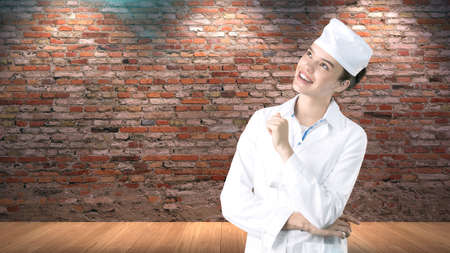 Beautiful medical woman doctor in uniform. Studio painted background. Concept of profitable health care.の写真素材