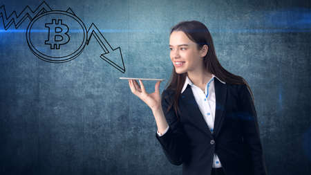 Successful business woman standing near btc. She needs to buy or sell Bitcoin. Concept of virtual criptocurrency.の写真素材