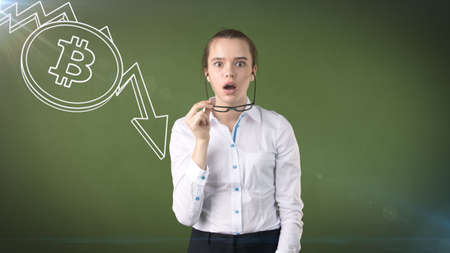 Woman standing near btc logo. Concept of virtual criptocurrency bitcoin dawnfall and correction.の写真素材