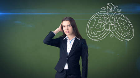 Successful business woman standing near btc logo. She needs to buy or sell Bitcoin. Concept of virtual criptocurrency.の写真素材