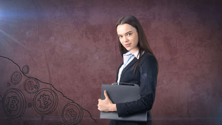 Beauty business woman standing near btc. Successful Bitcoin investment. Concept of virtual criptocurrency.の写真素材