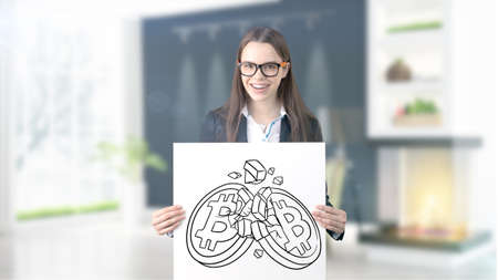 Surprised smiling young woman wearing a suit and looking at a cryptocurrency sketch on a design flat wall. Concept of Bitcoin risk.の写真素材
