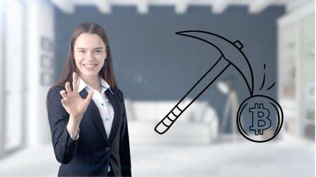 Surprised smiling young woman wearing a suit and looking at a cryptocurrency sketch on a design flat...