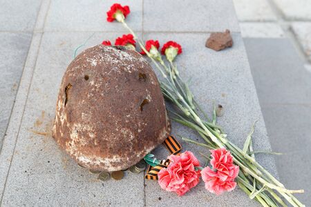 TAGANROG, RUSSIA - July 19, 2016: The soldier's helmet of times of World War II, lies at a monument devoted to Muisky heights. Taganrog, Russiaのeditorial素材