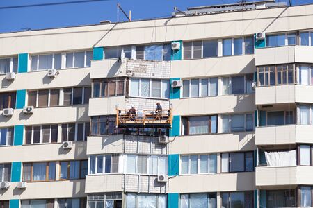 VOLGOGRAD, RUSSIA - July 02, 2016: Builders repair the inhabited multi-storey building. Volgograd, Russiaのeditorial素材
