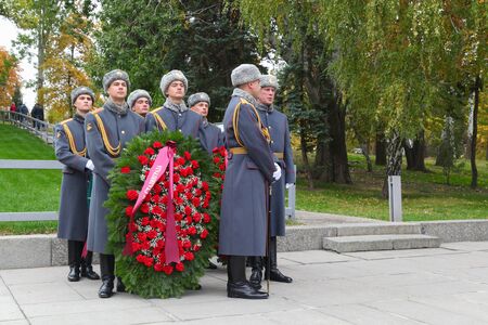 VOLGOGRAD, RUSSIA - October 15, 2017: Soldiers in a gray overcoat hold a wreath on a grave in hand...