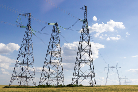 TAGANROG, RUSSIA - June 27, 2017: High-voltage support of an overhead power transmission line with the split wires in the field with a dry grass against the background of the blue sky in the summer afternoon のeditorial素材